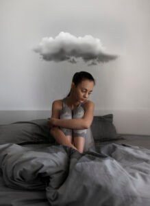 full-shot-sad-woman-sitting-bed